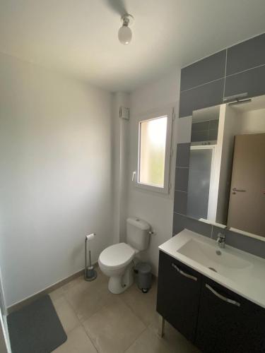 une salle de bain avec toilettes, lavabo et miroir dans l'établissement Villa Jasmin vue mer, à Sainte-Marie-la-Mer