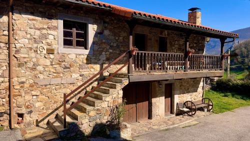 a stone building with a staircase on the side of it at Apartamentos rurales La Pornacal I y La Pornacal II in Villar de Vildas