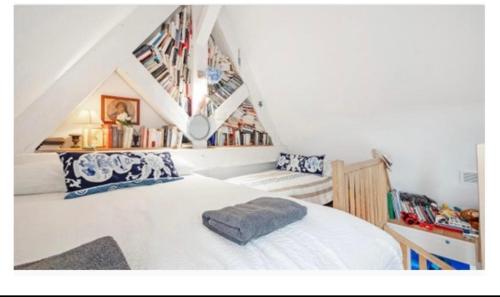 une chambre avec un lit blanc dans un grenier dans l'établissement Duplex La Vigie Kensington Pool Sea Vineyard View, à La Croix-Valmer