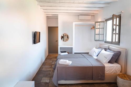 a bedroom with a large bed and a window at Living Blue Tinos in Kardiani