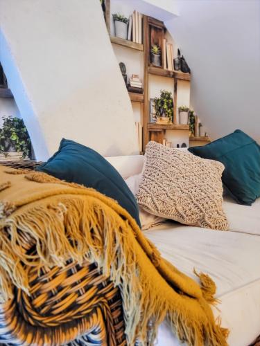 - un canapé avec une couverture et des oreillers dans l'établissement Nid douillet dans la cité des peintres, à Pont-Aven