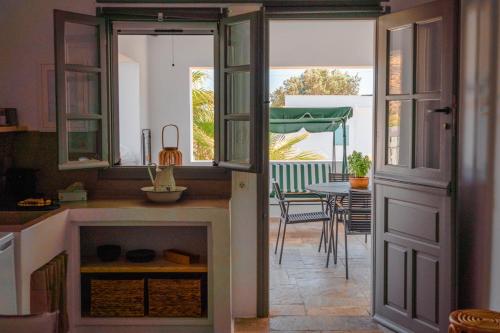 a kitchen with a door leading to a dining room at Living Blue Tinos in Kardiani
