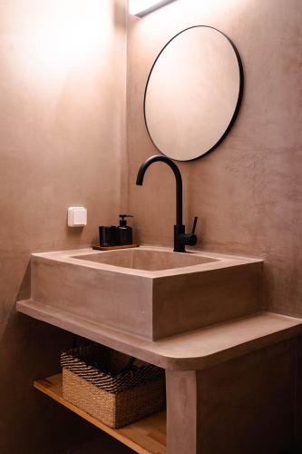 a bathroom with a sink with a mirror above it at Living Blue Tinos in Kardiani