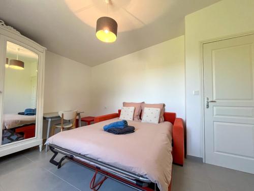 une chambre avec un lit et un miroir dans l'établissement Gîte à proximité de la plage du Rozel et du GR 223, à Le Rozel