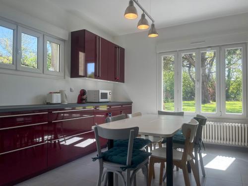 - une cuisine avec une table, des chaises, une table et des armoires dans l'établissement Gîte à proximité de la plage du Rozel et du GR 223, à Le Rozel