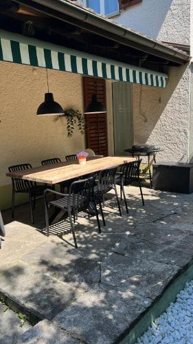 a wooden table and chairs on a patio at Gartenoase by Greatlifestay in Ennetbürgen