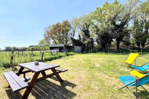 - une table de pique-nique et des chaises dans un champ dans l'établissement Longère rénovée entre terre et mer 5min des plages, à Guidel