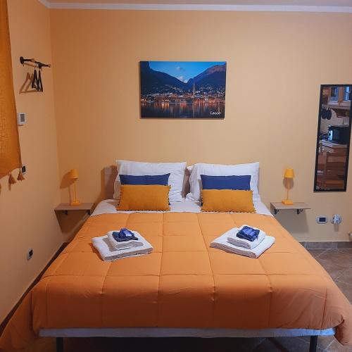 a bedroom with a large orange bed with towels on it at Il PETTIROSSO in Galbiate