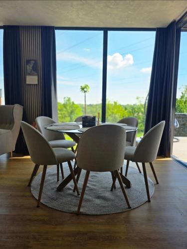a dining room with a table and chairs and a large window at Balans house in Petrovaradin