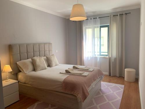 a bedroom with a large bed and a window at Lovely&Cozy apartment in Lagoa