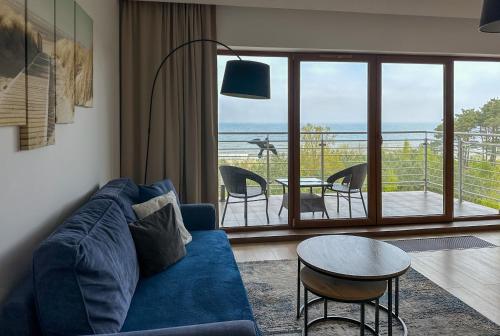 a living room with a blue couch and a table at FEWO Sea View East Tower Porta Mare in Dziwnówek