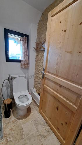 une salle de bain avec toilettes et porte en bois dans l'établissement Panarama maison neuve superbe vue, à Gouffern en Auge
