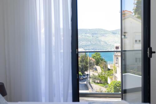 a room with a window with a view of the ocean at Apartments Ivo Herceg Novi in Herceg-Novi