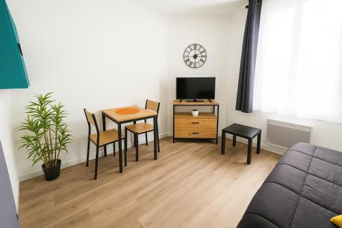 un salon avec une table et une télévision dans l'établissement Appartement Cerf3-Centre ville Meaux-Gare-Disney, à Meaux