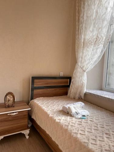 a bedroom with a bed with a dresser and a window at Shaki Best house in Sheki