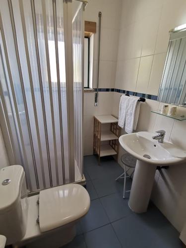 a bathroom with a toilet and a sink and a shower at Hotel Covilhã Jardim in Covilhã
