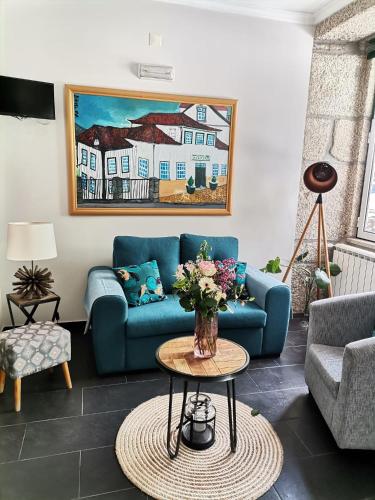 a living room with a blue couch and a table at Hotel Covilhã Jardim in Covilhã