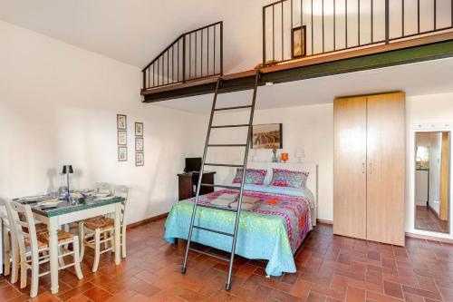a bedroom with a bed and a desk and a ladder at Agriturismo Antico Podere Il Polveraio in Montescudaio