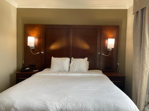 a bedroom with a large white bed with two lamps at Forestpark Suites in Cincinnati