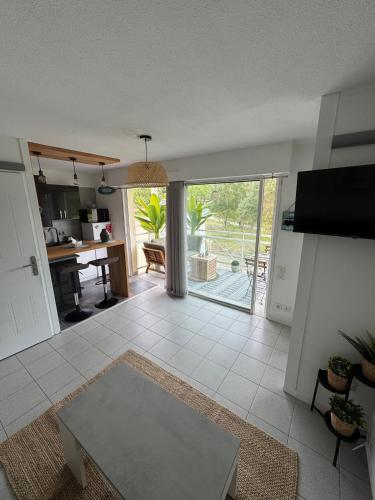 - un salon avec une table et une vue sur la cuisine dans l'établissement Ocean and forest golf studio, à Moliets-et-Maa