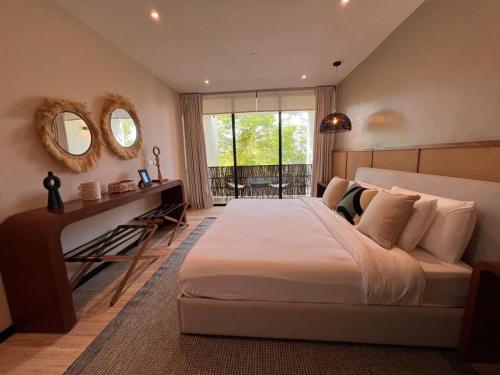a bedroom with a large bed and a desk and mirror at Penthouse Om in Tulum