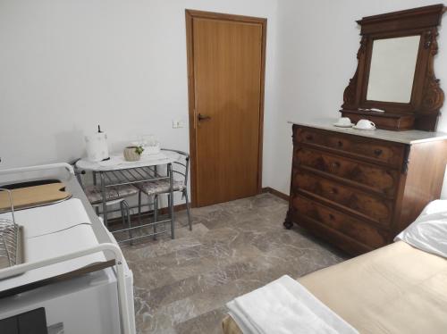 a bedroom with a dresser and a mirror and a table at La Lenzerina Casa indipendente con giardino in Scarlino