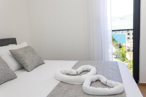 a bedroom with two heart shaped towels on a bed at Apartments Ivo Herceg Novi in Herceg-Novi