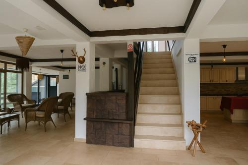 a lobby with a staircase and a table and chairs at Cabana Riverdale in Podu Dîmboviţei