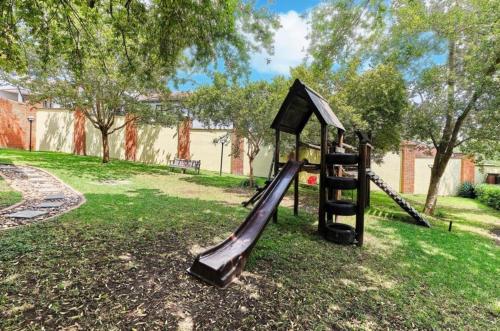 une aire de jeux avec un toboggan dans un parc dans l'établissement Lovely 2 Bedroom Apartment Near Monte Casino, à Sandton