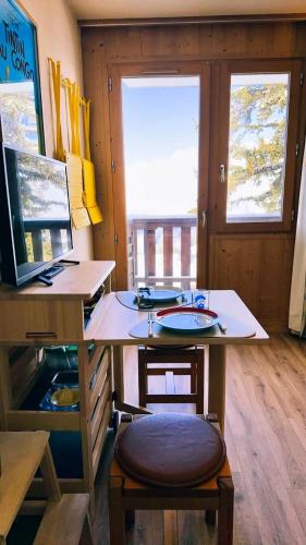 Cette chambre comprend un bureau avec une chaise et une table. dans l'établissement Résidence La Vanoise - Studio 2 personnes Vanoise MAE-2051, à Montvalezan