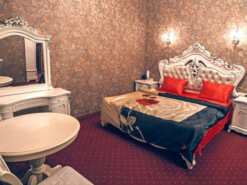 a bedroom with a bed and a table and a mirror at Piter Hotels in Saint Petersburg