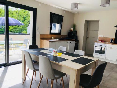 a kitchen and dining room with a table and chairs at Maison moderne 3 chambres SPA-jacuzzi juin-septembre in Cerelles
