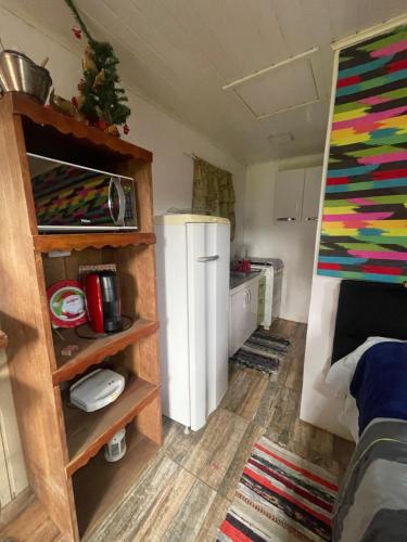 a small room with a refrigerator and a kitchen at Chale Sabrina in Campos do Jordão