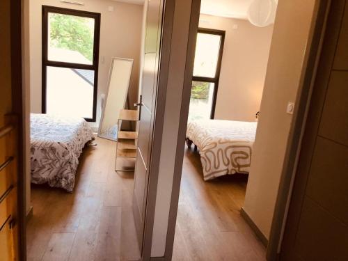 a room with two beds and a hallway with two windows at Maison moderne 3 chambres SPA-jacuzzi juin-septembre in Cerelles