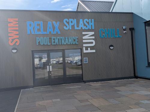 a building with a sign that reads relax splash pool entrance at LuKa25 GC080 in Saint Osyth