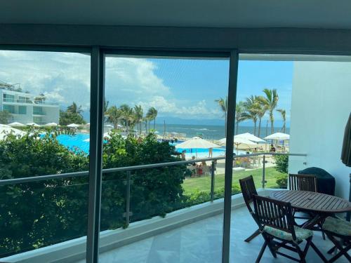 a balcony with a table and a view of the ocean at Aria Ocean Rentals - Riviera Nayarit in Nuevo Vallarta 