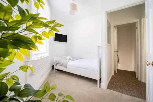 a white bedroom with a bed and a window at Larkhall Retreat- Village Centre, Parking, 4K TVs, 10mins To City Centre in Bath