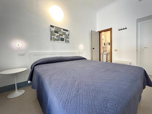 a bedroom with a blue bed and a table at Hotel Meublè Agavi in Monterosso al Mare