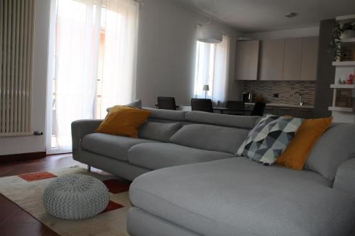 a living room with a gray couch and a kitchen at HildeGarda Pacengo in Pacengo di Lazise
