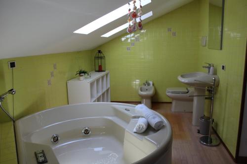 a green bathroom with a tub and a toilet at HildeGarda Pacengo in Pacengo di Lazise