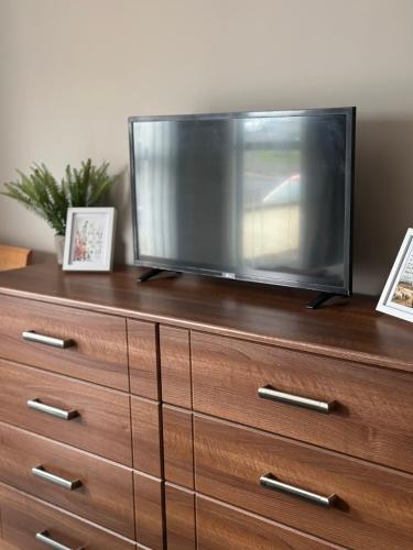 a flat screen tv sitting on top of a dresser at Atlantic Port Retreat in Portstewart