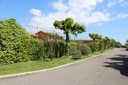 a bench sitting on the side of a road with bushes at HildeGarda Pacengo in Pacengo di Lazise