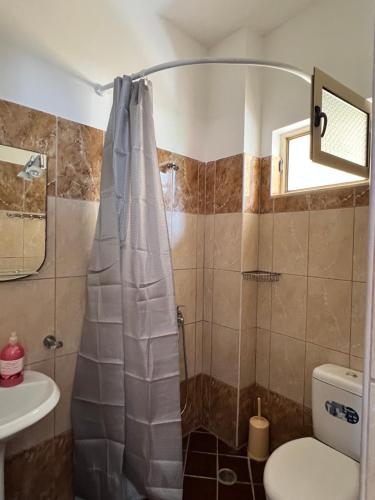 a bathroom with a shower with a toilet and a sink at Rock Star-Pllakat in Sarandë