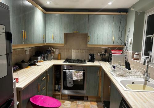 a kitchen with wooden cabinets and a pink stool at Private Room in Newmarket in Newmarket