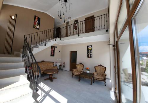 a staircase in a house with chairs and a table at Pensiunea Hanul Huniazilor HD in Hunedoara