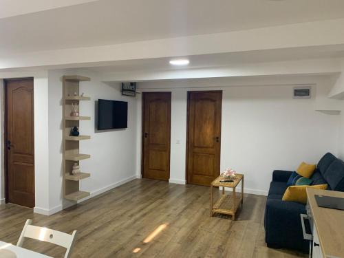 a living room with a blue couch and a tv at DBO Vivo 3 Rooms in Baia Mare