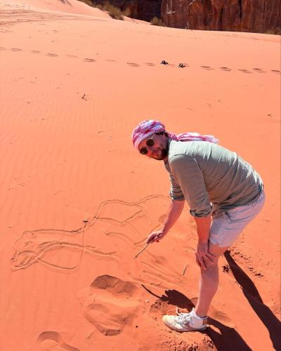 a man is standing in the desert at Talal Rum Luxury Camp in Jurf ad Darāwīsh