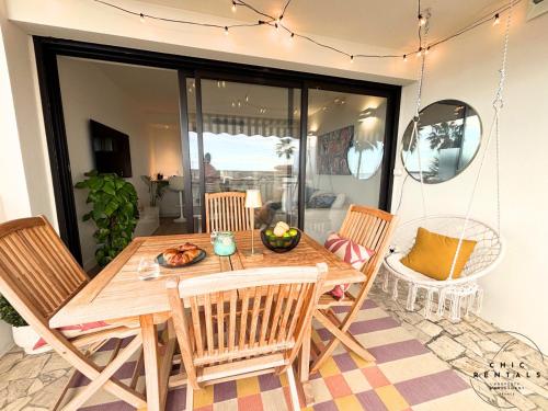 une salle à manger avec une table et des chaises en bois dans l'établissement Etoile du Cap - Beach Front 2 BDR Partial Sea View, à Cannes