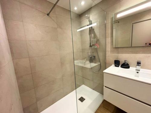 une salle de bain avec une douche en verre et un lavabo dans l'établissement Etoile du Cap - Beach Front 2 BDR Partial Sea View, à Cannes