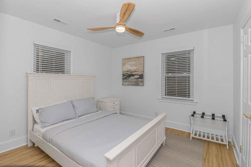 a white bedroom with a bed and a ceiling fan at Charming 2 bedroom retreat in Myrtle Beach